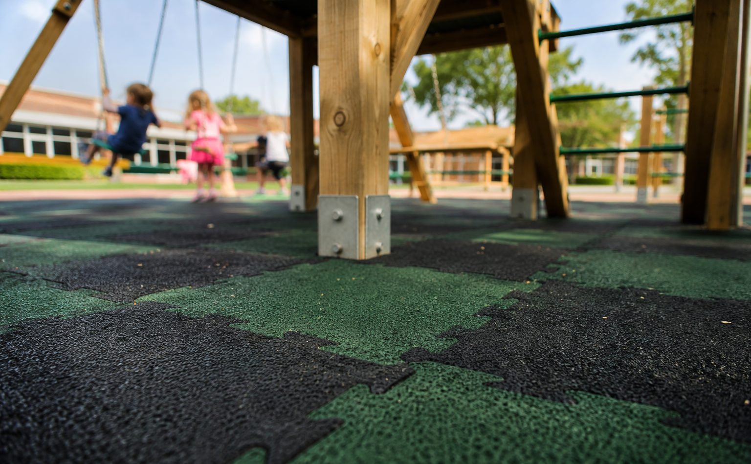 Impact-absorbing rubber safety tiles under a jungle gym